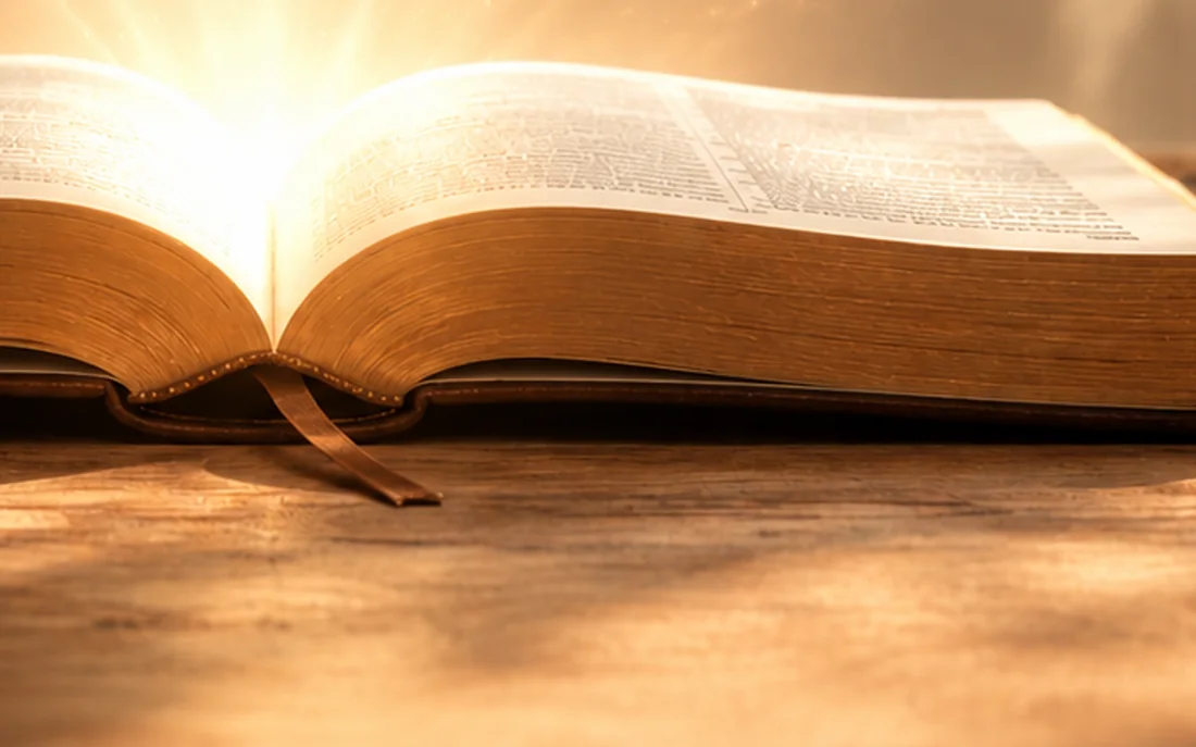 The ribbon marker lying across an open Bible